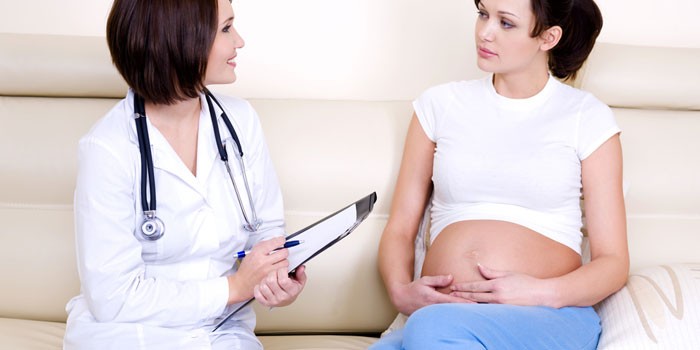 Беременная женщина у гинеколога в кабинете