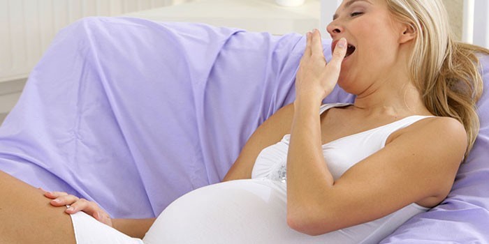 Беременная женщина зевает