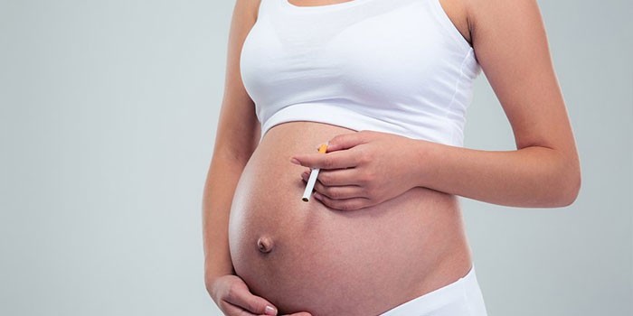 Беременная женщина с сигаретой