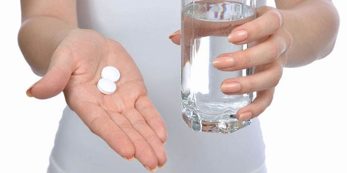 Женщина с таблетками и стаканом воды