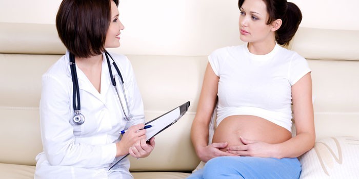 Беременная женщина беседует с врачом