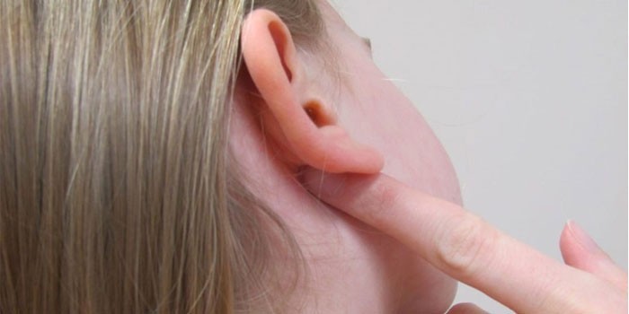 Девушка держит палец за ухом