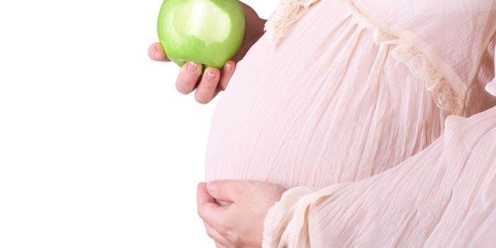 Беременная с яблоком в руке