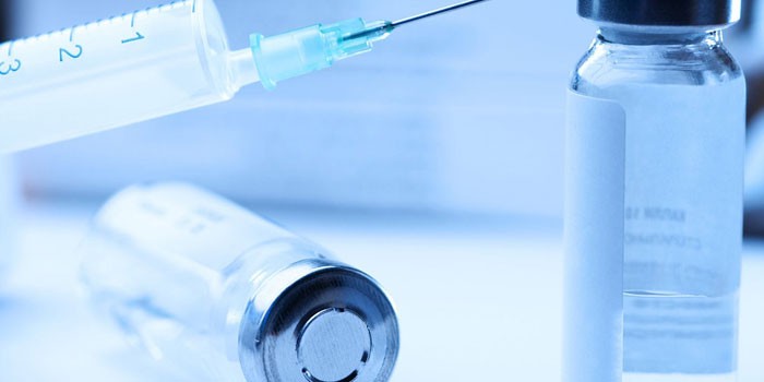 Вакцина во флаконе и медицинский шприц