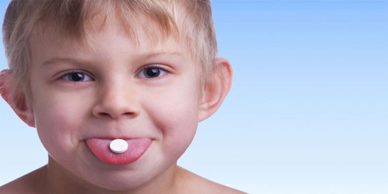 Ребенок с таблеткой на языке