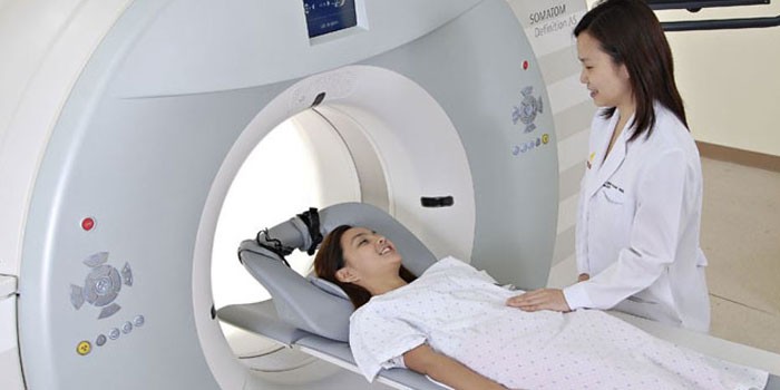 Девушка в аппарате МРТ и врач рядом