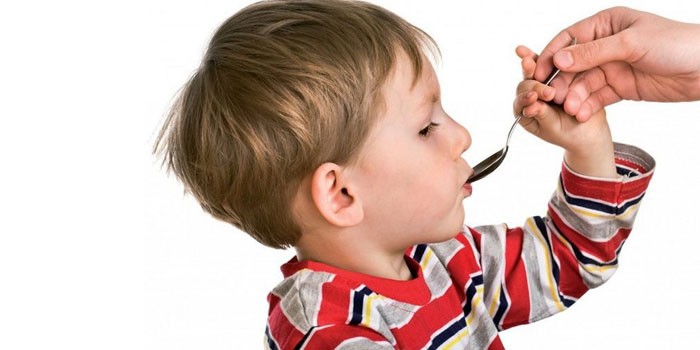 Мальчик пьет сироп из ложки