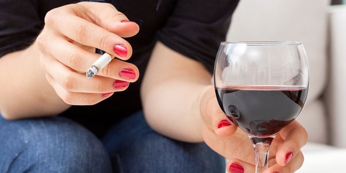 Женщина курит и пьет вино