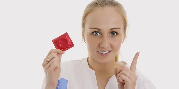 Медик с презервативом в руке